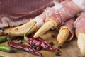 Grissini bread sticks with prosciutto on a wooden board with red and green pepper Royalty Free Stock Photo