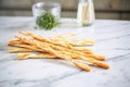 grissini breadsticks fanned out on a marble surface