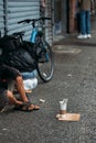 Gritty Scene of New York City Life with Homeless Person Seated by Bike Royalty Free Stock Photo