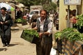 Grocer carrying vegetables to his stand on bazaar (market) in Iraq