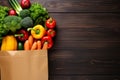 Groceries bag with fresh vegetables on a wooden background. Off-centered