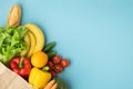 Grocery brown paper bag full of fresh fruits and vegetables on blue background. Shopping and delivery service concept Royalty Free Stock Photo