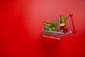 grocery consumer basket.Rising food prices.Shopping cart with groceries on a red background.Vegetables and fruits price Royalty Free Stock Photo