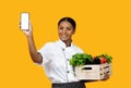 Grocery Market App. Cheerful Black Chef Woman Showing Smartphone With Empty Screen Royalty Free Stock Photo