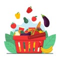 Grocery shopping concept. Red plastic shopping basket full of groceries products. Fruits and vegetables falling down into basket,