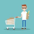 Grocery shopping concept: Young customer standing with a trolley Royalty Free Stock Photo