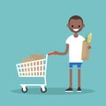 Grocery shopping concept: Young customer standing with a trolley Royalty Free Stock Photo