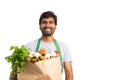 Grocery store employee holding fresh vegetable bag