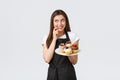 Grocery store employees, small business and coffee shops concept. Cheerful silly waitress want have bite of delicious Royalty Free Stock Photo