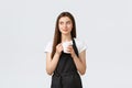 Grocery store employees, small business and coffee shops concept. Pleased cute saleswoman in black apron enjoying break