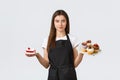 Grocery store employees, small business and coffee shops concept. Waitress in cafe holding plates with cupcakes and cafe