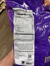 Grocery store Hand holding Taki chips fuego ingredients label