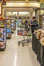 Grocery Store - Market with two women on phones as they wait with carts to check out - Pharmacy in background Royalty Free Stock Photo