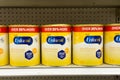 Grocery store shelf with canisters of Enfamil brand baby formula