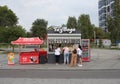 a grocery street kiosk sells food for customers, a queue of tourists in a cafe