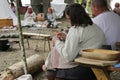 Woman repairs her historical costume. Nomads on a halt in forest