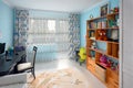 Grodno, Belarus, AUGUST 2020: Cozy bright children`s room with blue walls pastel carpet on gray wooden floor wooden Royalty Free Stock Photo