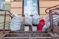 Grodno, Belarus, February 25, 2022: New arrival of clothes in a second-hand store. Old used clothes in large plastic bags.