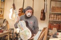 GRODNO, BELARUS - JANUARY 18, 2017. Serious professional guitar-maker going with unfinished guitar at workshop