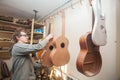 GRODNO, BELARUS - JANUARY 18, 2017. Serious professional guitar-maker working with unfinished guitar at workshop