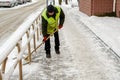 snow storm in the city. Roads and sidewalks covered with snow. Worker shovel clears snow. Bad