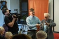 Grodno, Belarus, January 16, 2019: A young reporter holding a microphone. Conversation with an elderly man on stage. The retiree