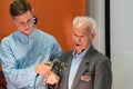 Grodno, Belarus, January 16, 2019: A young reporter holding a microphone. Conversation with an elderly man on stage. The retiree