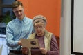 Grodno, Belarus, January 16, 2019: A young reporter holding a microphone. Conversation with an elderly man on stage. The retiree