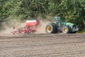 Grodno, Belarus, June 22, 2020: In the agricultural field, sowing equipment works. The tractor drives through the field leaving Royalty Free Stock Photo