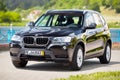 GRODNO, BELARUS - JUNE 2020: BMW X3 II F25 2.0i xDrive front three fourth view outdoors on sunny road background of