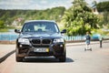 GRODNO, BELARUS - JUNE 2020: BMW X3 II F25 2.0i xDrive selective focus front view with boys passing by on hoverboards Royalty Free Stock Photo