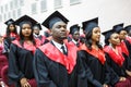 GRODNO, BELARUS - JUNE, 2018: Foreign african medical students in square academic graduation caps and black raincoats during