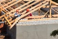 GRODNO, BELARUS - JUNE 2020: Two workers roofers in helmets surrounded by rafters and beams at construction site build house. Pair Royalty Free Stock Photo