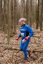 Cute elderly caucasian women wearing sportswear running through a forest