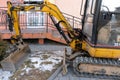 Grodno, Belarus, March 22, 2022: Mini excavator Caterpillar on the construction site. Replacement of paving slabs and repair of