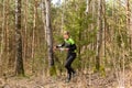Strong caucasian young woman wearing sportswear running through a forest