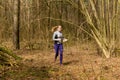 Strong caucasian young woman wearing sportswear running through a forest