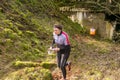 Strong caucasian young woman wearing sportswear running through a forest