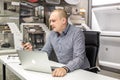 GRODNO, BELARUS - MARCH 2019: young man employees works at the computer in modern luxury plumbing store