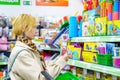 Grodno, Belarus, May 20, 2023: An attractive blonde girl in a toy store chooses a gift for a child. A girl in a shopping mall