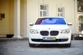 Grodno, Belarus, May 2013: Modern luxury BMW 750Li XDrive car front view parked on stone paved parking near ancient house