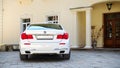 Modern luxury BMW 750Li XDrive car rear back view parked on stone paved parking near ancient house horizontal Royalty Free Stock Photo