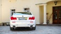 Modern luxury BMW 750Li XDrive car rear back view parked on stone paved parking near ancient house horizontal Royalty Free Stock Photo