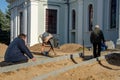 Grodno, Belarus, October 21, 2018: a group of builders engaged in the repair of a Catholic church. Laying a new sidewalk. Chief