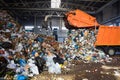 GRODNO, BELARUS - OCTOBER 2018: recycling plant process of unloading garbage from garbage truck. Manipulator loads garbage on con