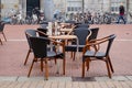 European cafe tables and wicker chairs on a brick-laid city street