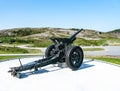 Gronsvik, Norway - August 06, 2019: Back right view at artilery gun standing in front of Main building of museum of Gronsvik