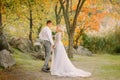Groom affectionately looks at the bride in a gray steep wedding expensive dress with a long train, gently holds her hand