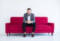 Groom with bearded sitting on sofa red and smiling in formal tuxedo and suit in wedding day on white background,Copy space for tex