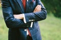 Groom in a blue plaid suit, white shirt and red tie stands with his arms crossed over his chest. Close-up Royalty Free Stock Photo